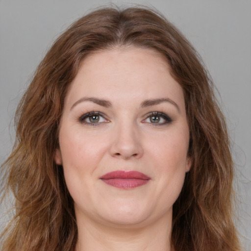 Joyful white young-adult female with long  brown hair and green eyes