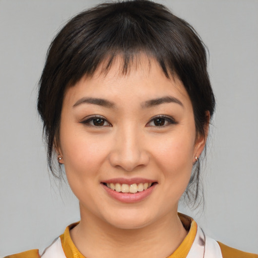 Joyful asian young-adult female with medium  brown hair and brown eyes