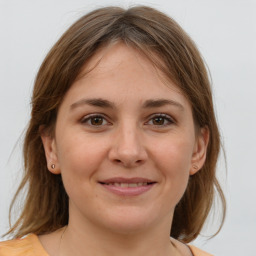 Joyful white young-adult female with medium  brown hair and grey eyes