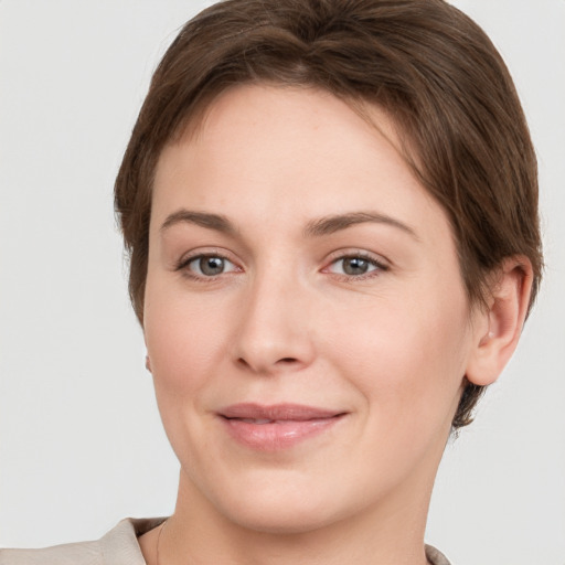 Joyful white young-adult female with short  brown hair and grey eyes