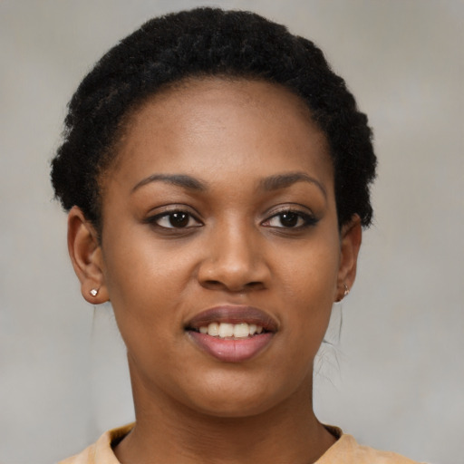 Joyful black young-adult female with short  black hair and brown eyes