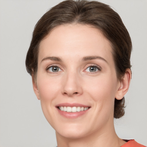 Joyful white young-adult female with short  brown hair and grey eyes