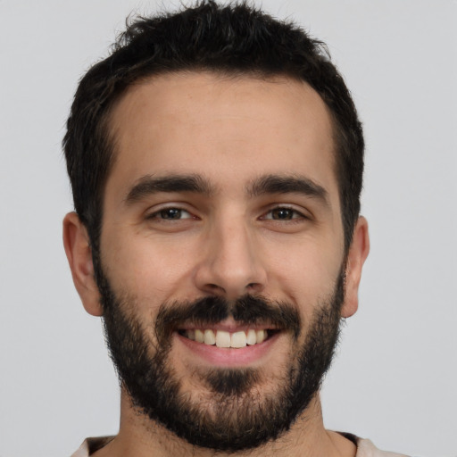 Joyful white young-adult male with short  black hair and brown eyes