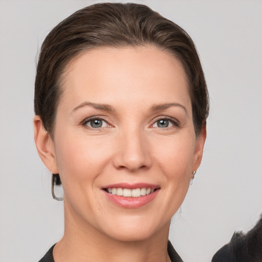 Joyful white young-adult female with short  brown hair and grey eyes