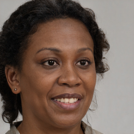 Joyful black adult female with medium  brown hair and brown eyes