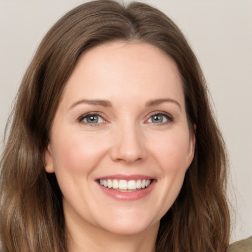 Joyful white young-adult female with long  brown hair and green eyes