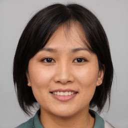 Joyful asian young-adult female with medium  brown hair and brown eyes