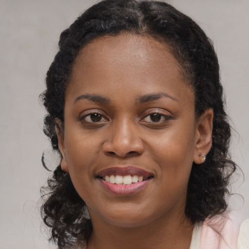 Joyful black young-adult female with medium  black hair and brown eyes