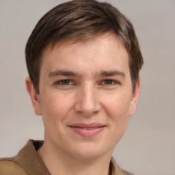 Joyful white young-adult male with short  brown hair and grey eyes