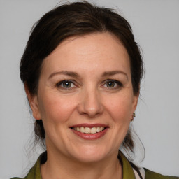 Joyful white adult female with medium  brown hair and brown eyes