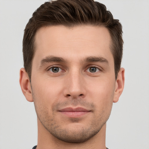 Joyful white young-adult male with short  brown hair and grey eyes