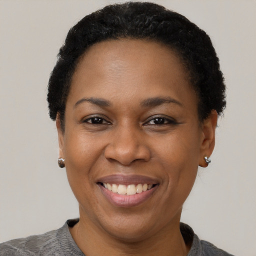 Joyful black adult female with short  black hair and brown eyes