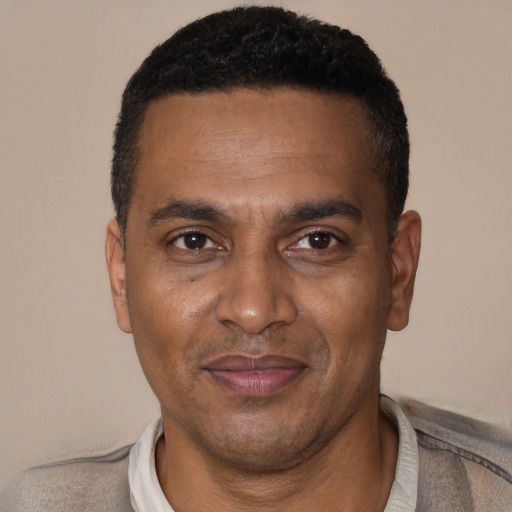 Joyful black adult male with short  brown hair and brown eyes