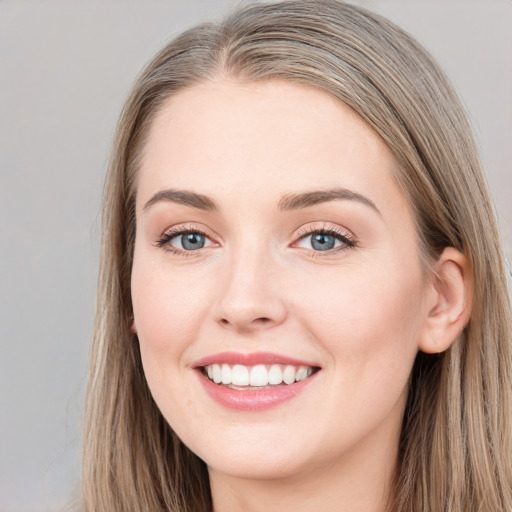 Joyful white young-adult female with long  brown hair and blue eyes