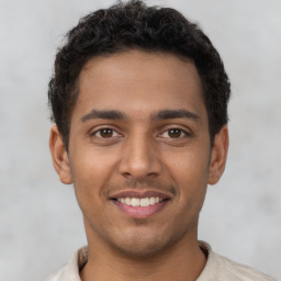 Joyful latino young-adult male with short  brown hair and brown eyes