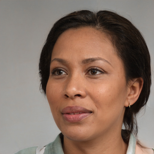 Joyful black adult female with medium  brown hair and brown eyes