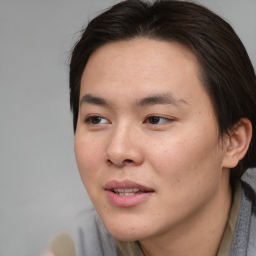 Joyful asian young-adult male with medium  brown hair and brown eyes