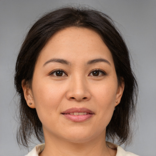 Joyful asian young-adult female with medium  brown hair and brown eyes