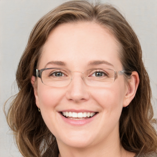 Joyful white adult female with long  brown hair and blue eyes