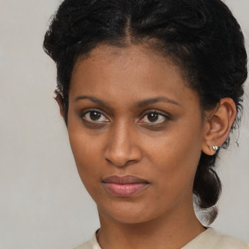 Joyful black young-adult female with medium  brown hair and brown eyes