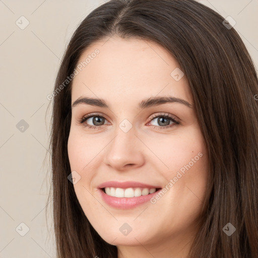 Joyful white young-adult female with long  brown hair and brown eyes