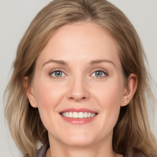 Joyful white young-adult female with medium  brown hair and blue eyes