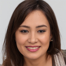 Joyful asian young-adult female with long  brown hair and brown eyes