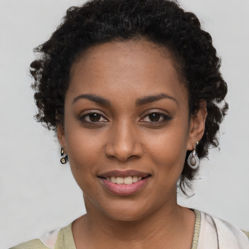 Joyful black young-adult female with short  black hair and brown eyes