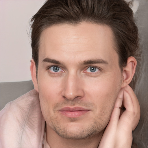 Joyful white young-adult male with short  brown hair and grey eyes