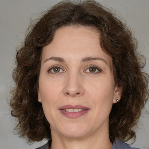 Joyful white adult female with medium  brown hair and green eyes