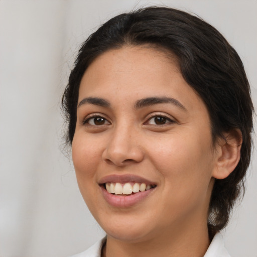 Joyful latino young-adult female with medium  brown hair and brown eyes