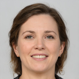 Joyful white adult female with medium  brown hair and grey eyes