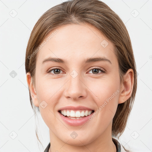 Joyful white young-adult female with medium  brown hair and grey eyes