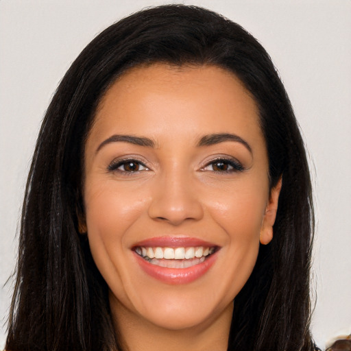 Joyful latino young-adult female with long  brown hair and brown eyes