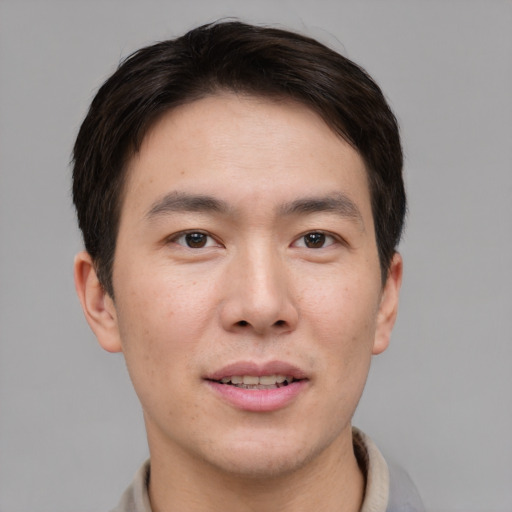 Joyful asian young-adult male with short  brown hair and brown eyes