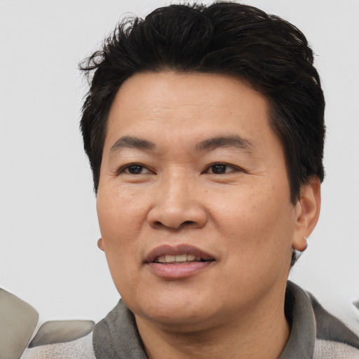 Joyful asian adult male with short  black hair and brown eyes