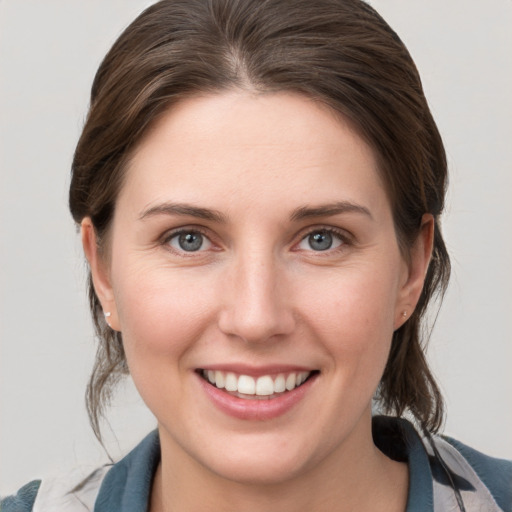 Joyful white young-adult female with medium  brown hair and grey eyes