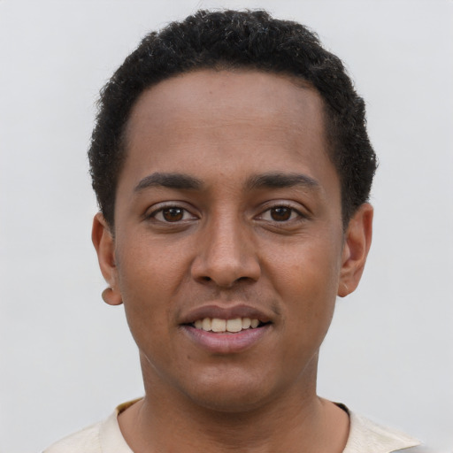 Joyful black young-adult male with short  brown hair and brown eyes