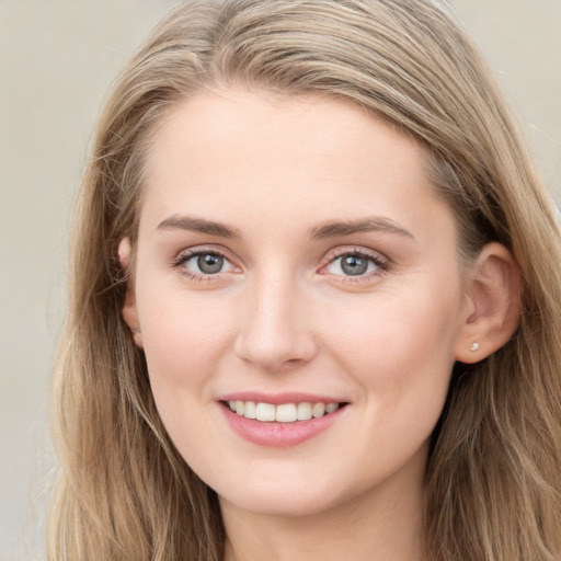 Joyful white young-adult female with long  brown hair and blue eyes