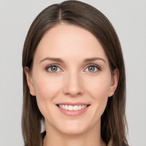 Joyful white young-adult female with long  brown hair and grey eyes