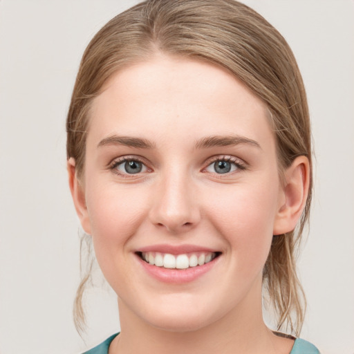 Joyful white young-adult female with medium  brown hair and blue eyes