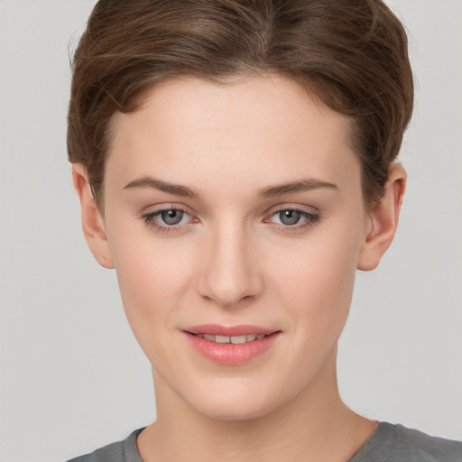 Joyful white young-adult female with short  brown hair and grey eyes