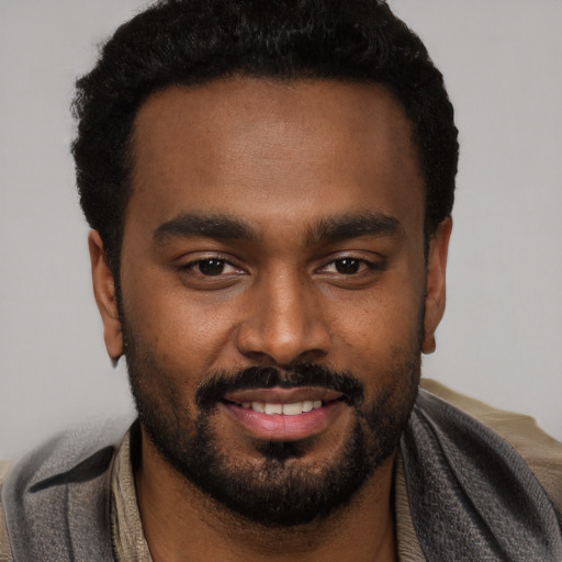 Joyful black young-adult male with short  black hair and brown eyes
