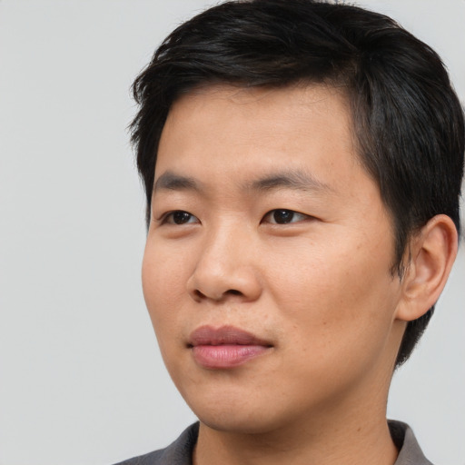 Joyful asian young-adult male with short  black hair and brown eyes