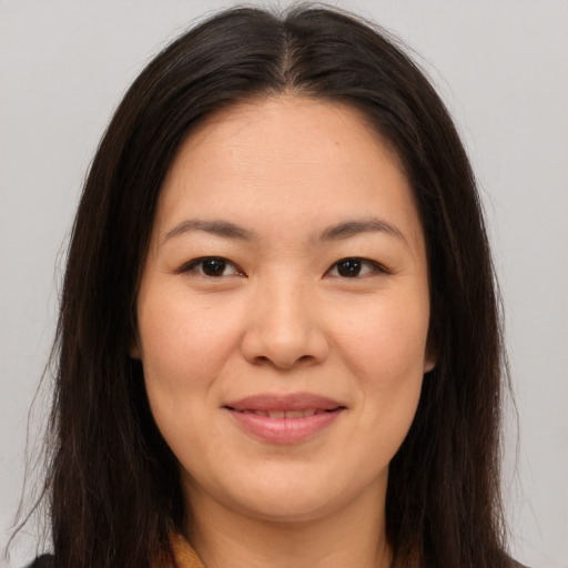 Joyful asian young-adult female with long  brown hair and brown eyes