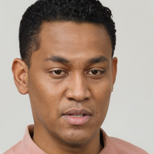 Joyful black young-adult male with short  brown hair and brown eyes