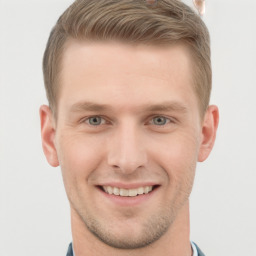 Joyful white young-adult male with short  brown hair and grey eyes