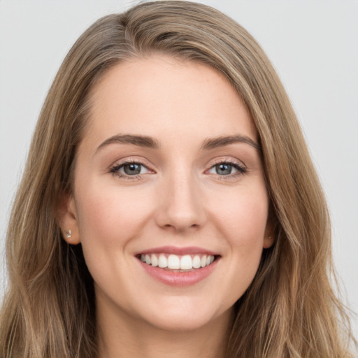 Joyful white young-adult female with long  brown hair and grey eyes