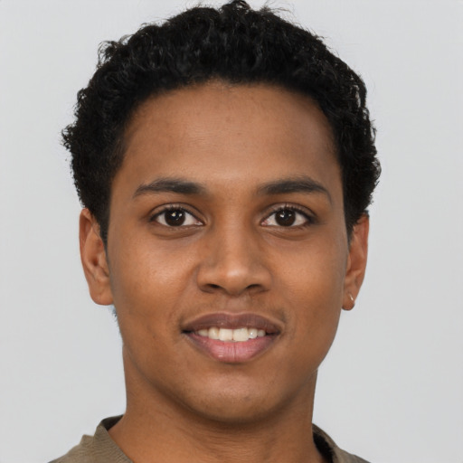 Joyful black young-adult male with short  brown hair and brown eyes