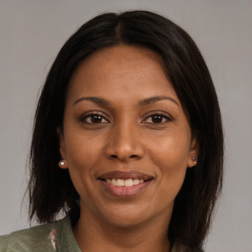 Joyful black adult female with medium  brown hair and brown eyes